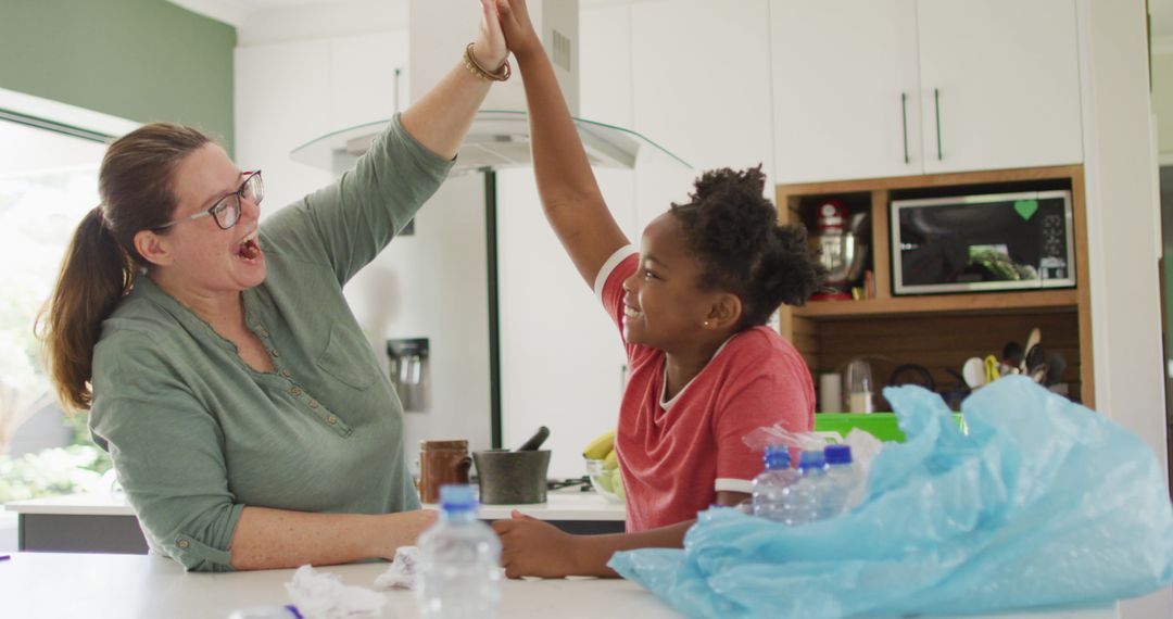 Mother and Daughter Joyfully Sorting Waste in Kitchen