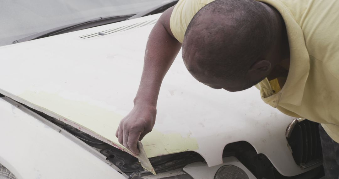 Man Repairing Car Hood with Sandpaper - Free Images, Stock Photos and Pictures on Pikwizard.com