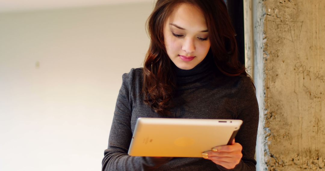 Young Woman Focused While Using Digital Tablet Indoors - Free Images, Stock Photos and Pictures on Pikwizard.com