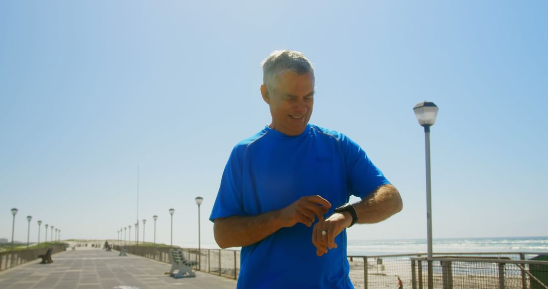 Active Senior Man Using Smartwatch on Beach Promenade