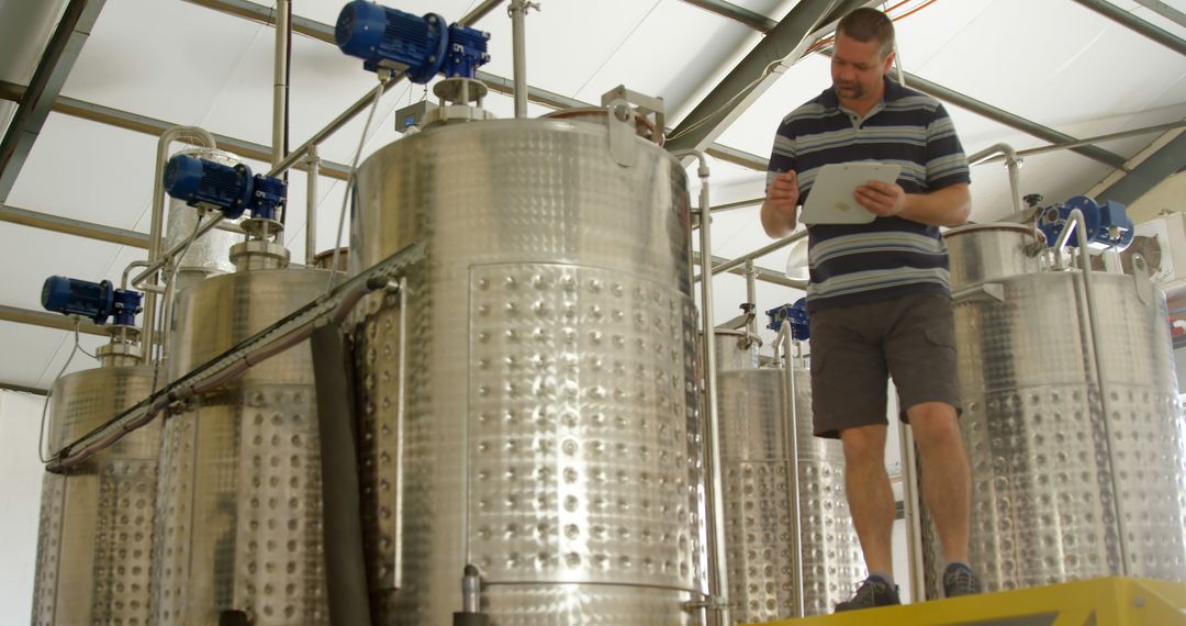 Technician Inspecting Fermentation Tanks in a Winery - Free Images, Stock Photos and Pictures on Pikwizard.com