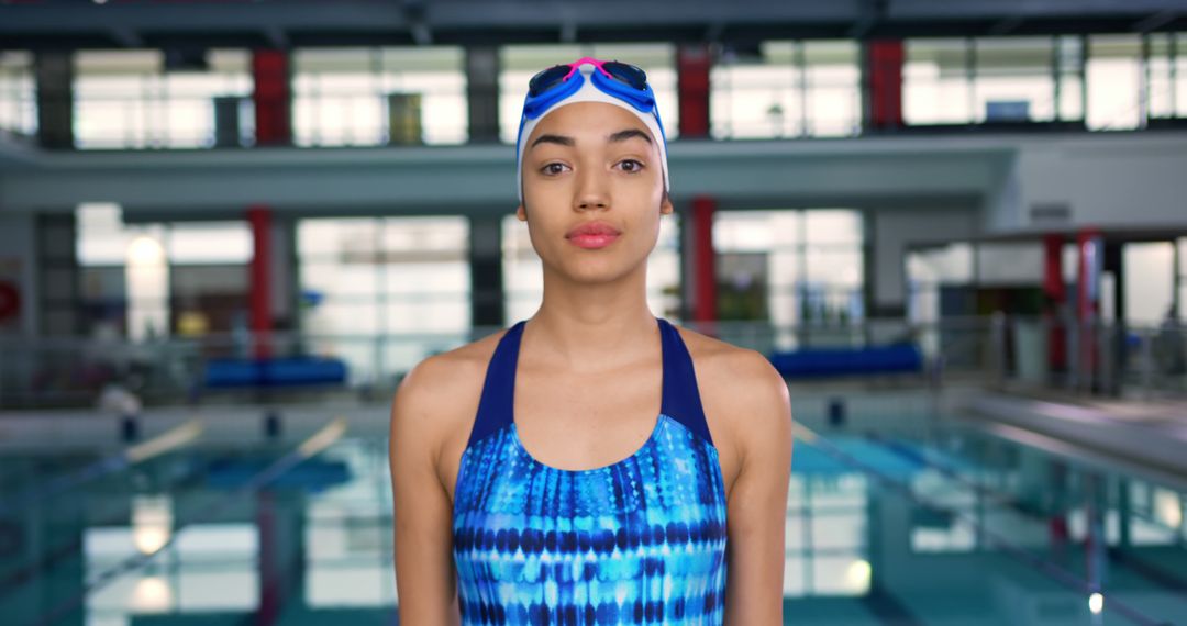 Portrait of biracial woman wearing swimsuit at swimming pool in sports centre - Free Images, Stock Photos and Pictures on Pikwizard.com