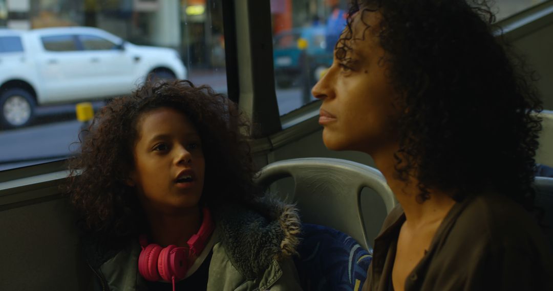 Mother and Daughter Taking a Bus Ride Together in Evening Urban Setting - Free Images, Stock Photos and Pictures on Pikwizard.com