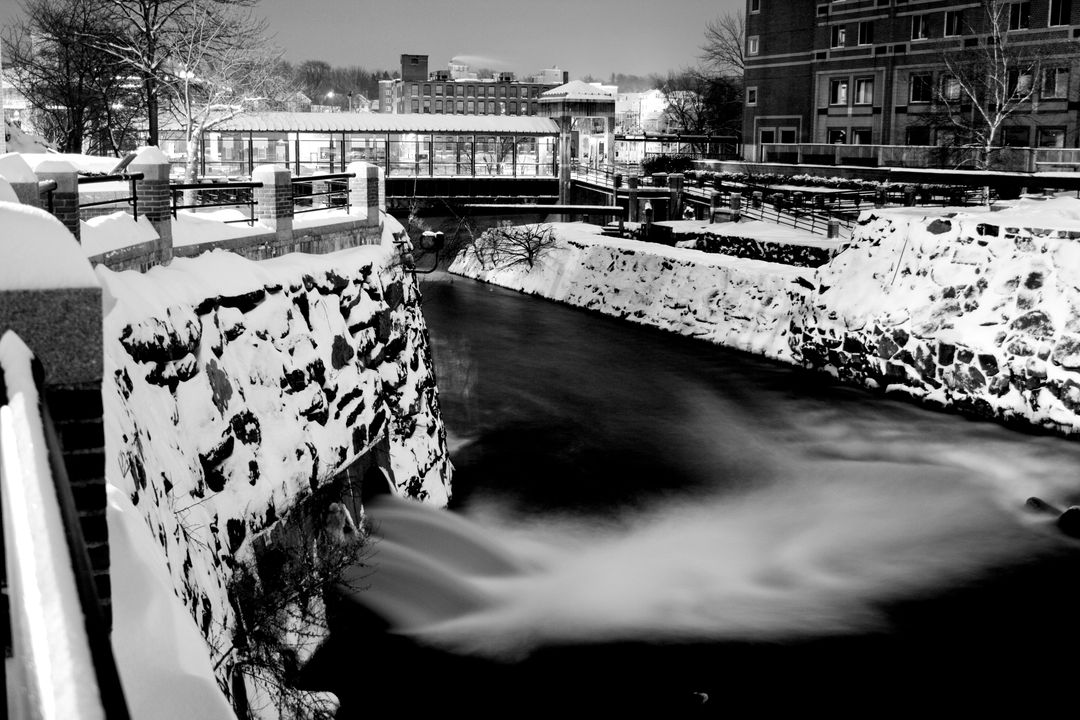 Serene Snowy River Flowing Through Urban Area at Night - Free Images, Stock Photos and Pictures on Pikwizard.com