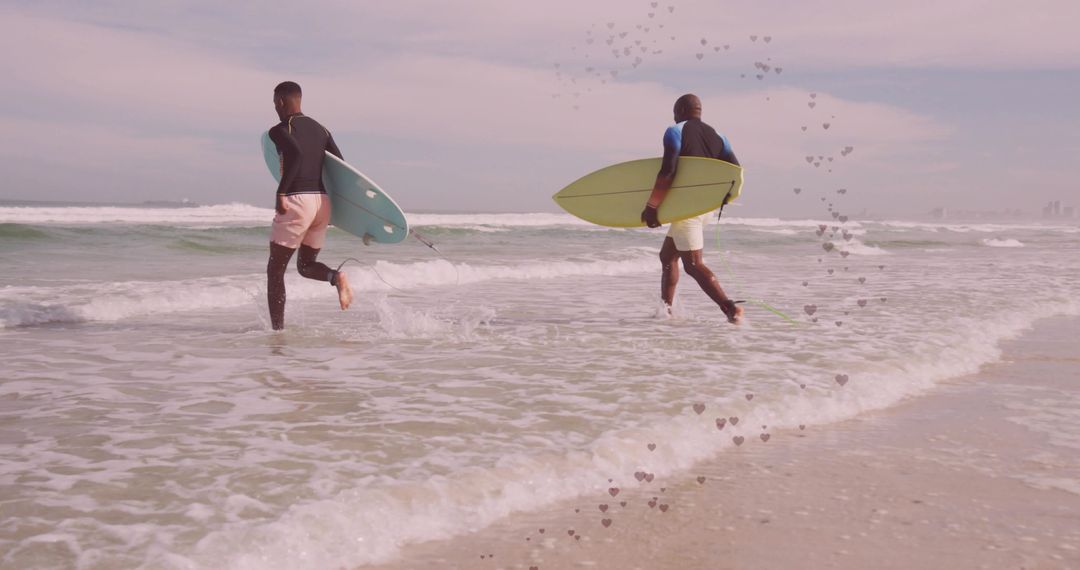 Two Friends with Surfboards in Wetsuits Walking into Ocean