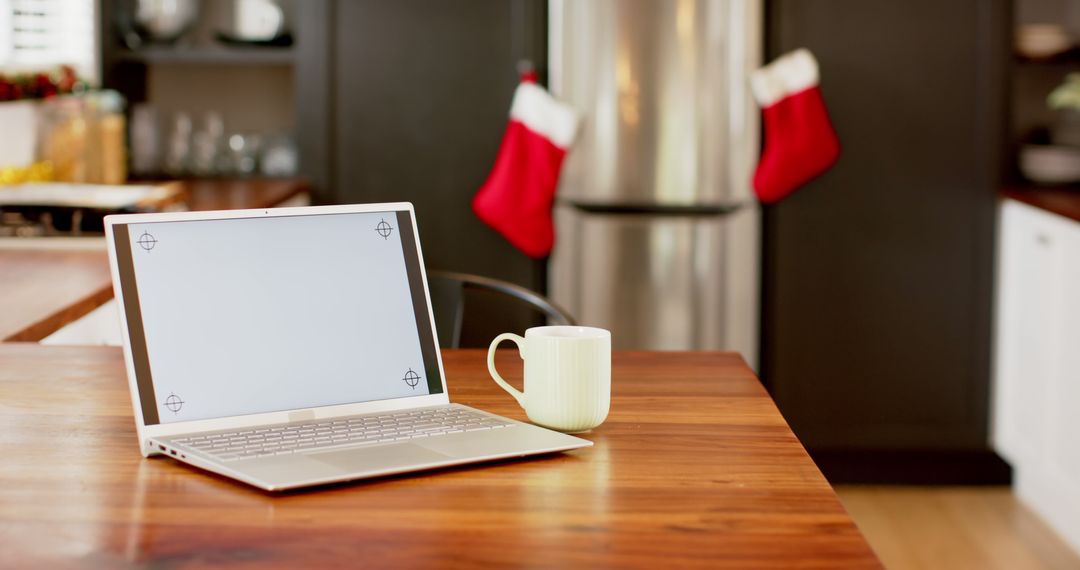 Cozy Kitchen Workspace with Laptop and Coffee Mug During Holidays - Free Images, Stock Photos and Pictures on Pikwizard.com