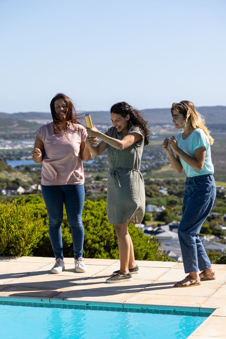 Friends Celebrating by Pool with Party Popper