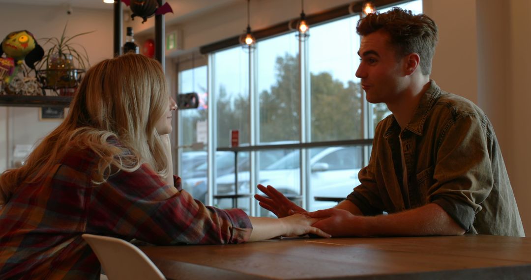 Young Couple Having a Conversation in a Cafe - Free Images, Stock Photos and Pictures on Pikwizard.com