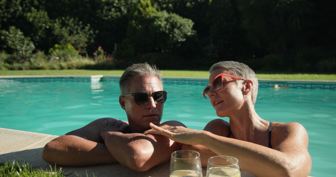 Senior Couple Relaxing by Backyard Pool with Drinks