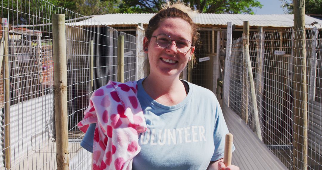 Cheerful Volunteer in a Sunlit Dog Shelter Holding Towel - Free Images, Stock Photos and Pictures on Pikwizard.com