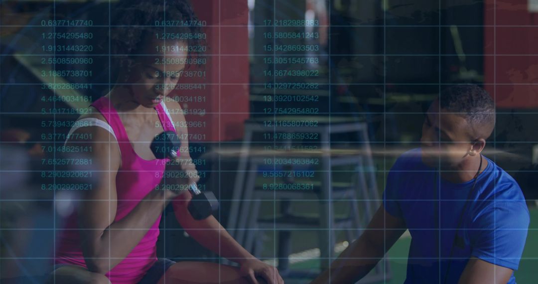 Woman lifting dumbbell while trainer monitoring performance metrics overlay in gym