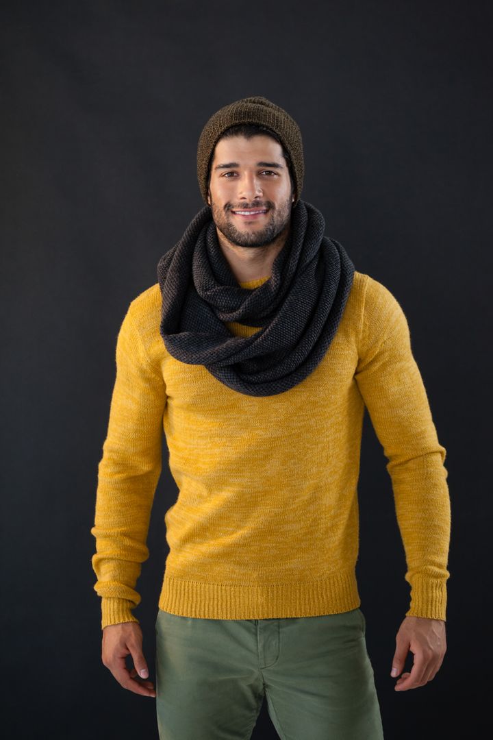Smiling Man in Yellow Sweater and Scarf Posing Against Black Background - Free Images, Stock Photos and Pictures on Pikwizard.com