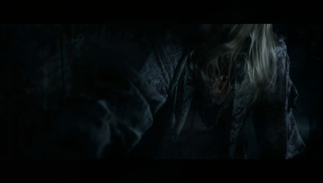 Enigmatic Woman Reaching Out in Dimly Lit Room