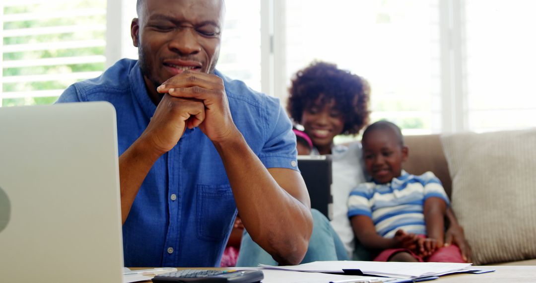 Stressed African American Father Working from Home with Family - Free Images, Stock Photos and Pictures on Pikwizard.com