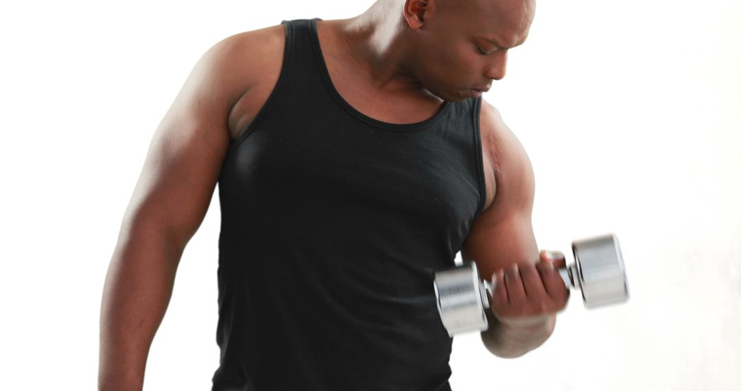 Focused African-American Man Lifting Dumbbell for Strength Training - Free Images, Stock Photos and Pictures on Pikwizard.com