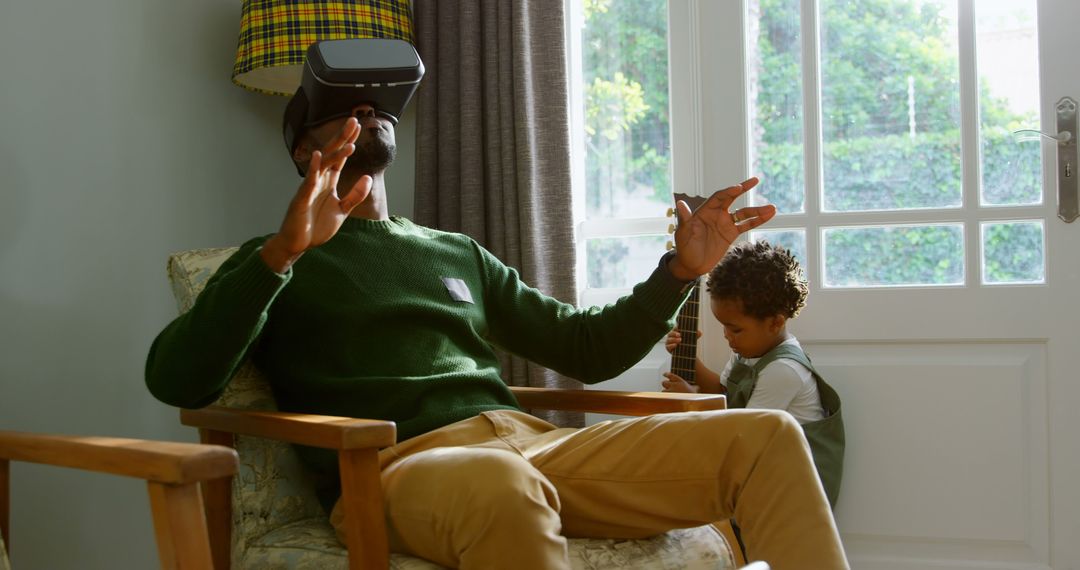 Father using VR headset while young daughter playing in living room - Free Images, Stock Photos and Pictures on Pikwizard.com