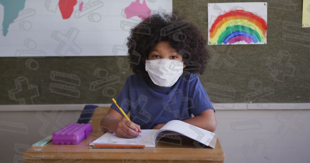 Schoolboy Wearing Mask Writing at Desk Amidst COVID-19 Safety Protocols