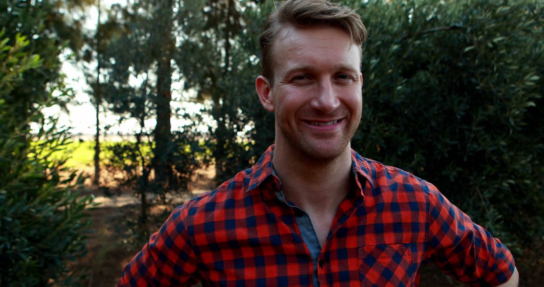 Smiling Man Wearing Red Plaid Shirt Outdoors on Sunny Day - Free Images, Stock Photos and Pictures on Pikwizard.com