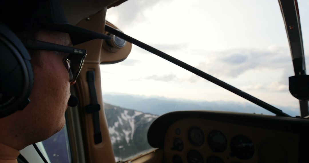 Pilot Navigating Small Aircraft Over Mountainous Terrain
