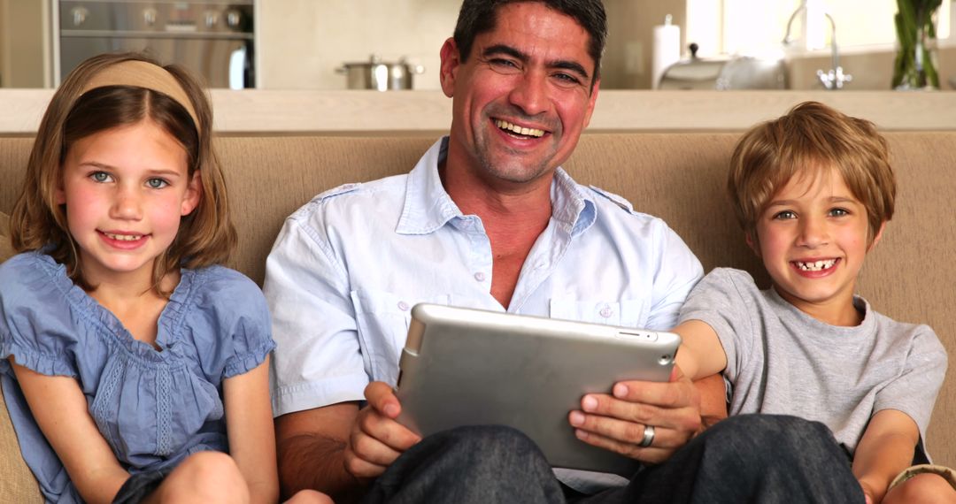 Father Sharing Tablet with Son and Daughter on Couch at Home - Free Images, Stock Photos and Pictures on Pikwizard.com