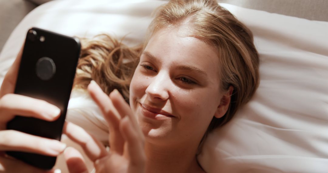 Smiling Woman Using Smartphone in Bed - Free Images, Stock Photos and Pictures on Pikwizard.com