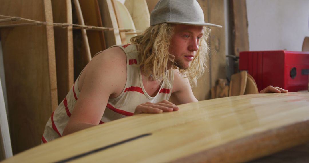 Surfboard Artisan Inspecting Handmade Wooden Surfboard in Workshop - Free Images, Stock Photos and Pictures on Pikwizard.com