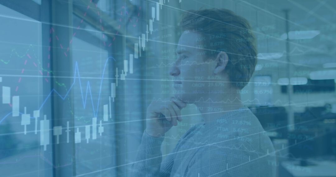 Man Analyzing Financial Data with Graph Overlay in Modern Office