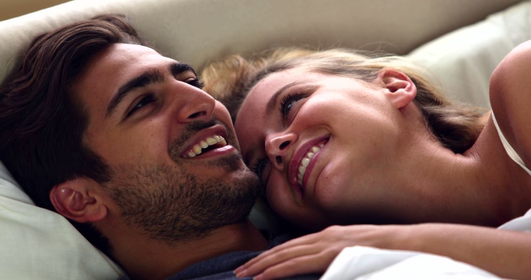 Happy Couple Smiling While Lying on Bed Enjoying Close Moment - Free Images, Stock Photos and Pictures on Pikwizard.com