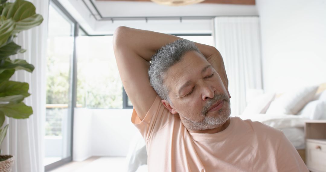 Senior Man Stretching Neck at Home with Peaceful Expression - Free Images, Stock Photos and Pictures on Pikwizard.com