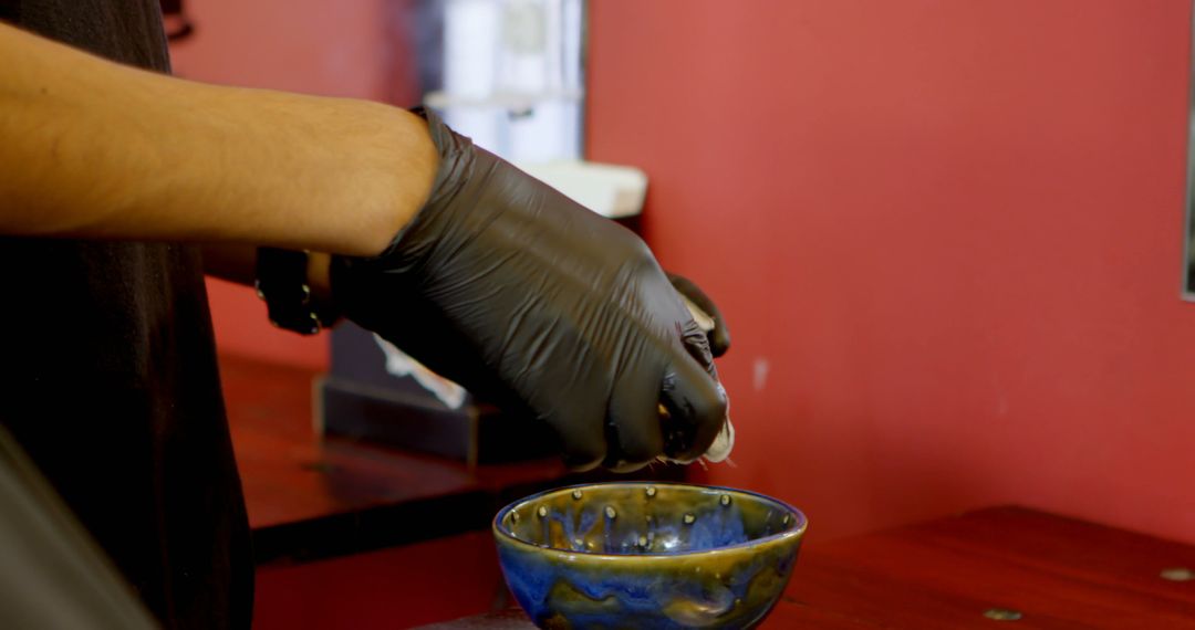 Close-up of Hand Mixing Tattoo Ink in Bowl with Gloves - Free Images, Stock Photos and Pictures on Pikwizard.com