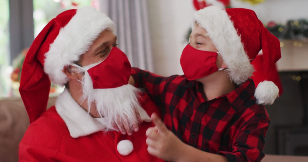 Father and Son Celebrating Christmas Wearing Santa Costumes and Masks - Free Images, Stock Photos and Pictures on Pikwizard.com