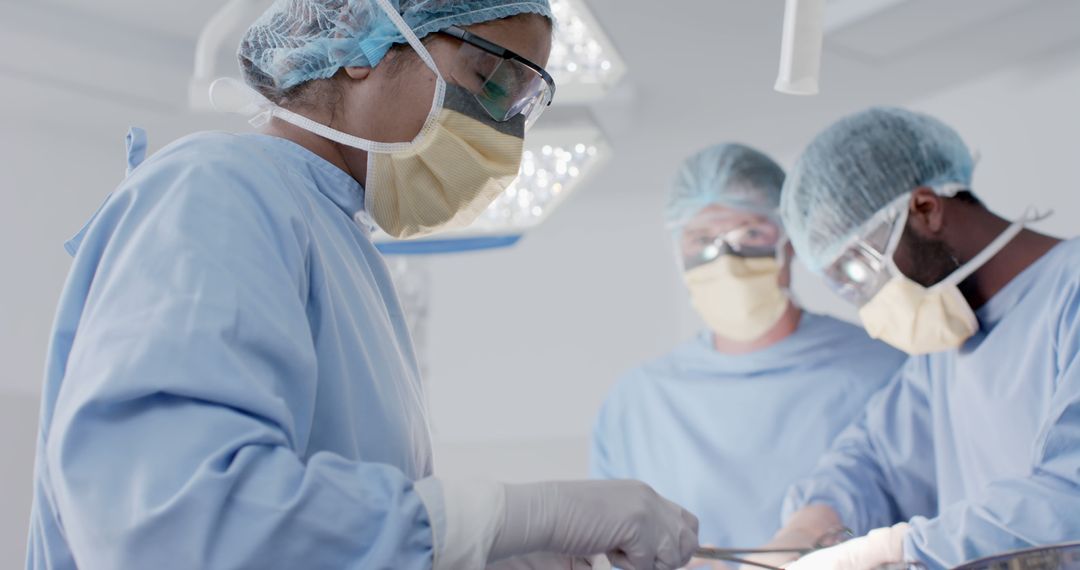Diverse male and female surgeons with face masks during surgery - Free Images, Stock Photos and Pictures on Pikwizard.com