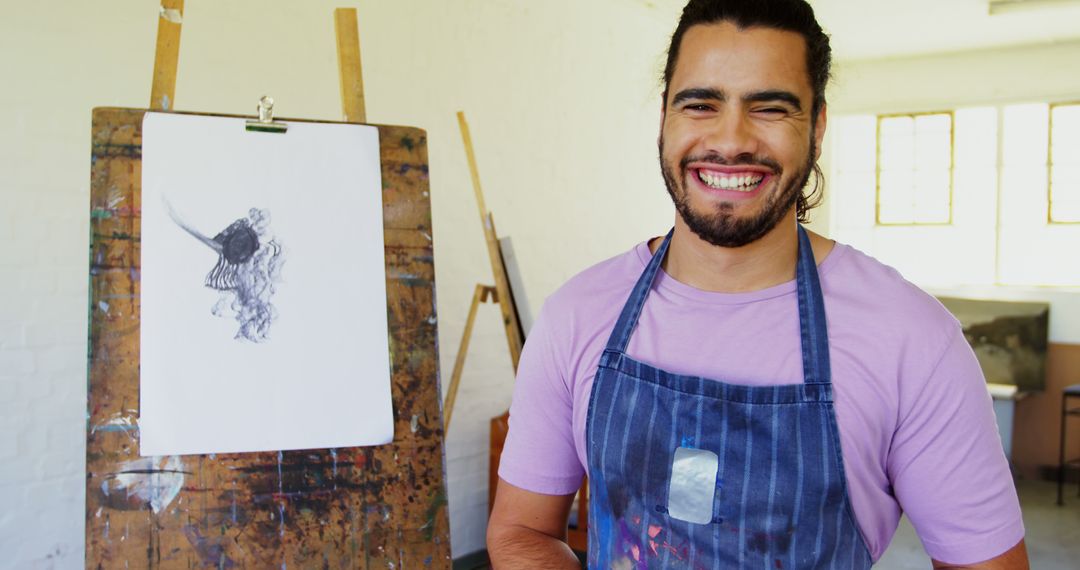 Smiling Artist in Studio with Drawing on Easel - Free Images, Stock Photos and Pictures on Pikwizard.com