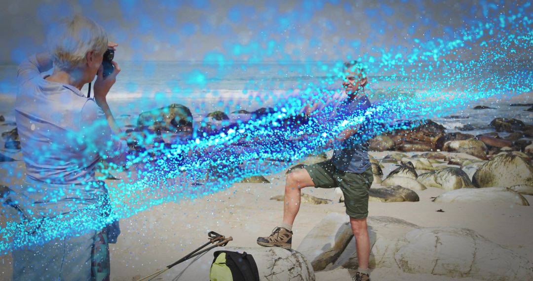 Senior couple exploring coastline photographing seals while posing on boulder