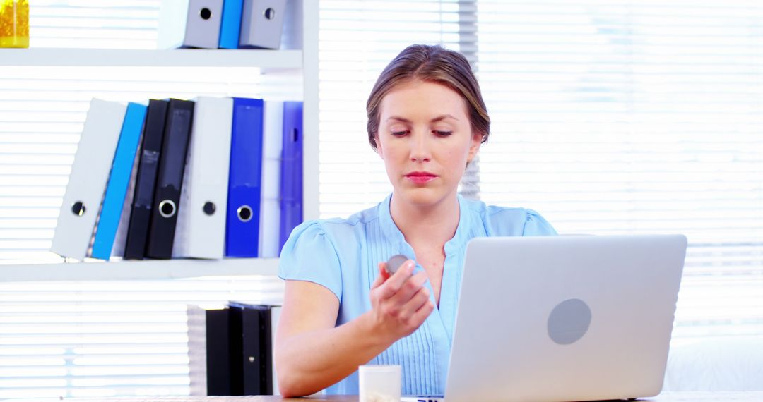 Young Businesswoman Taking Medication at Her Office Desk - Free Images, Stock Photos and Pictures on Pikwizard.com