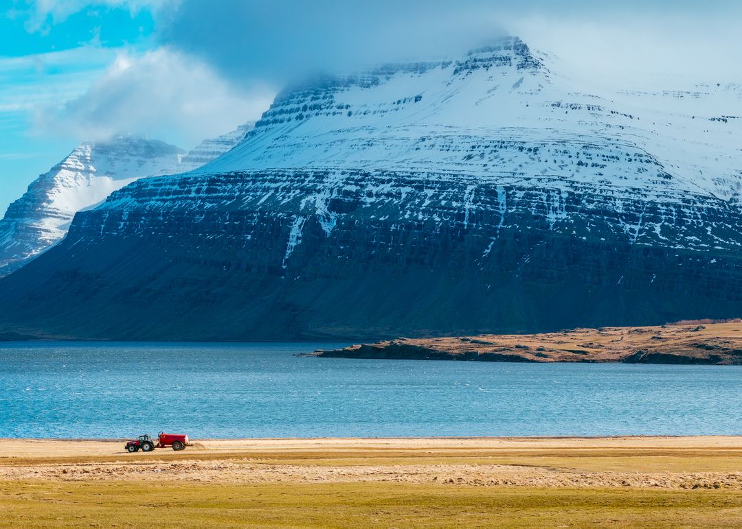 Snow-capped Mountains and Tractor Near Serene Lake in Icelandic Countryside - Free Images, Stock Photos and Pictures on Pikwizard.com