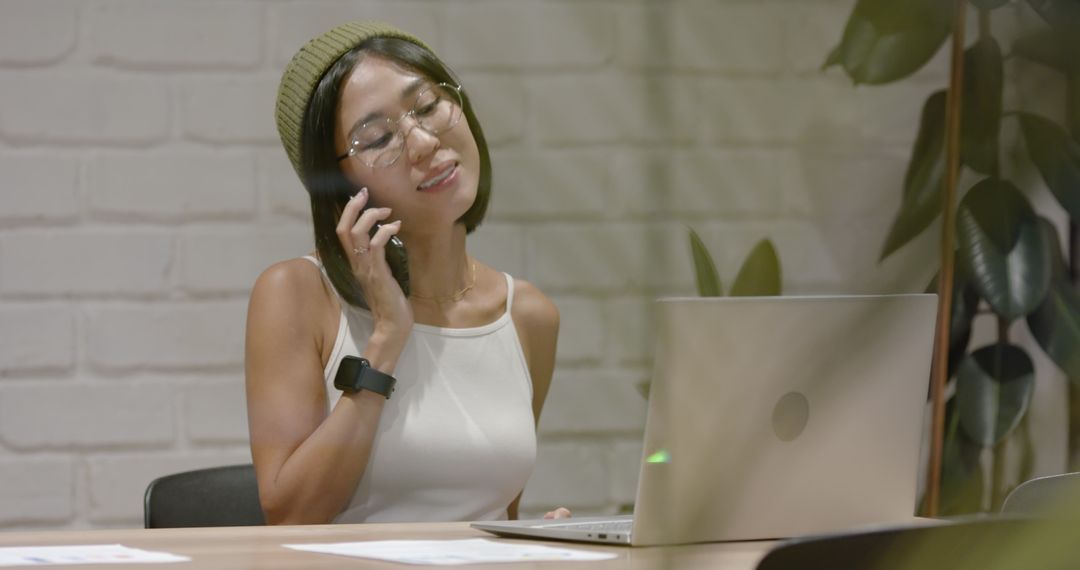 Asian Woman Engaged in Dynamic Office Meeting While Multitasking