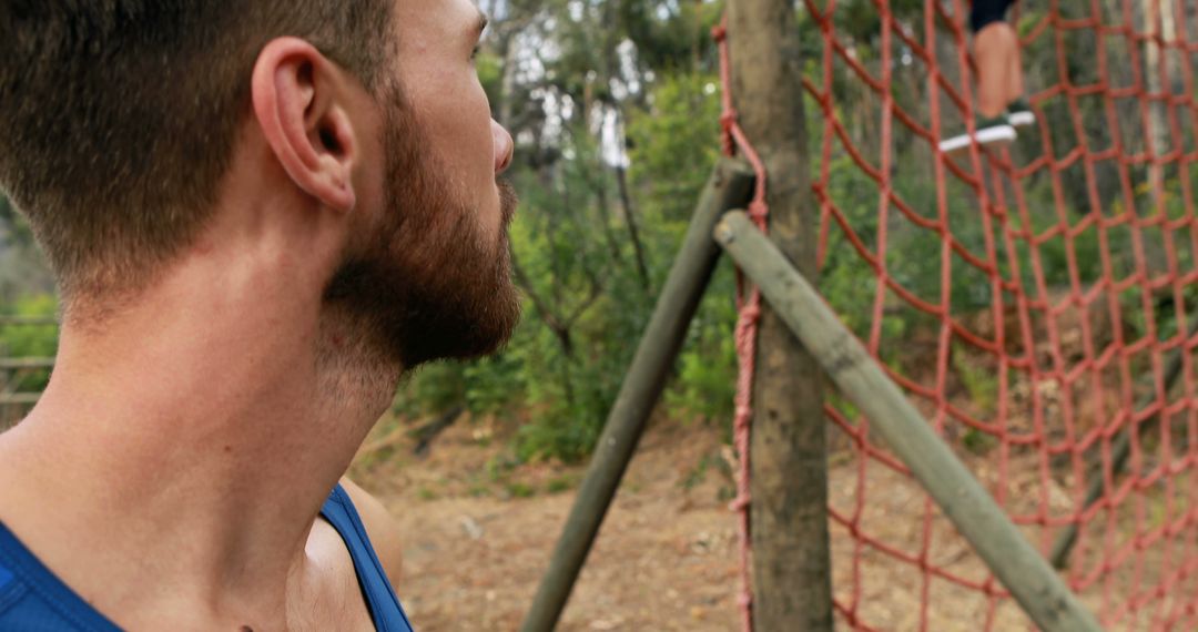 Man Observing Partner Climbing Net in Outdoor Training Course - Free Images, Stock Photos and Pictures on Pikwizard.com