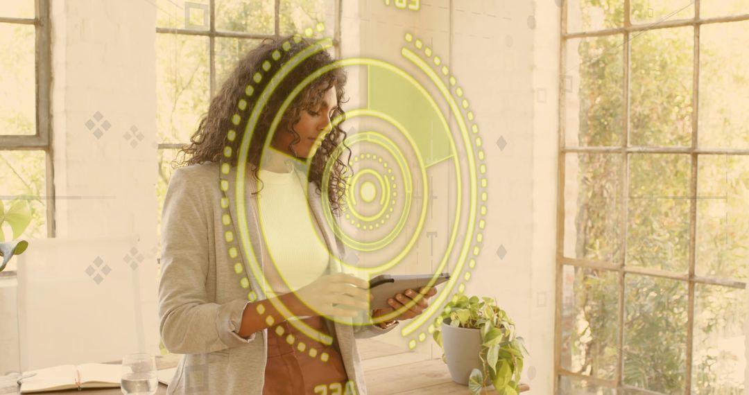 Holding tablet and reviewing augmented reality interface in sunlit modern office