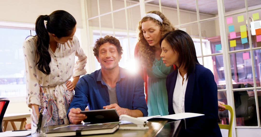 Diverse Team Collaborating Using Digital Tablet in Modern Office