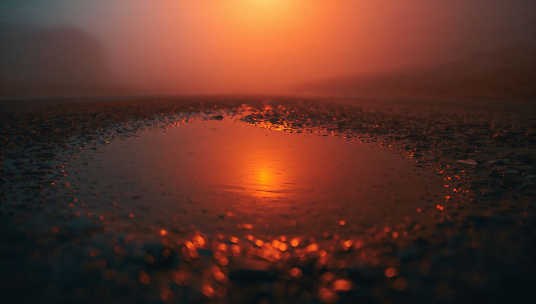 Sunset Reflection in Puddle on Pebbly Shoreline