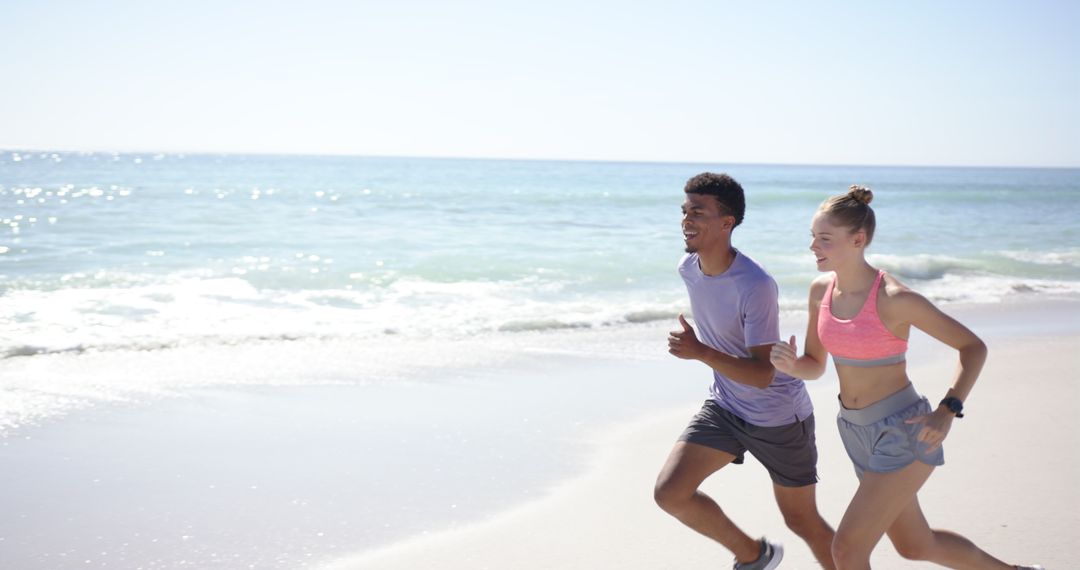 Young Couple Enjoying Beach Run on Sunny Day