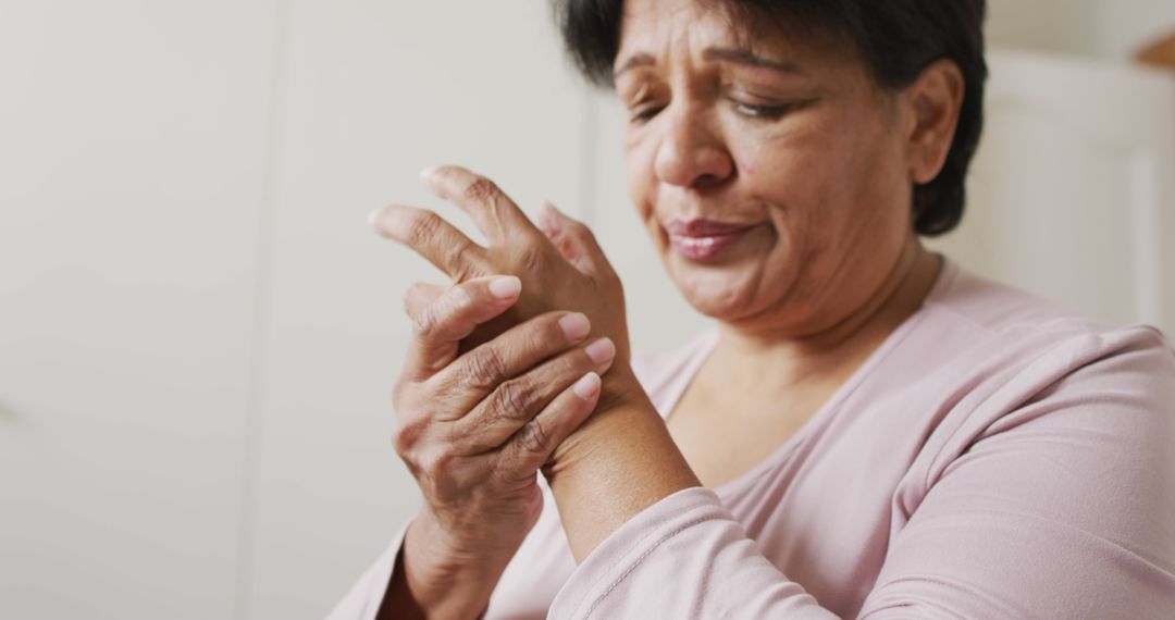 Senior Woman Experiencing Wrist Pain from Arthritis in Living Room - Free Images, Stock Photos and Pictures on Pikwizard.com