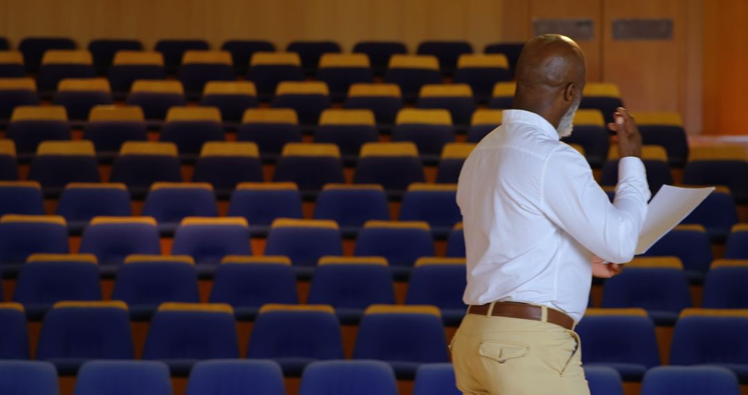 Senior Businessman Rehearsing in Empty Auditorium