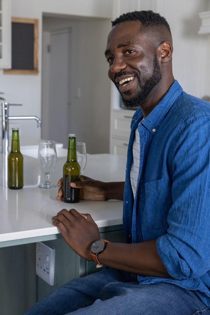 Man Enjoying Casual Relaxation in Modern Kitchen with Drinks