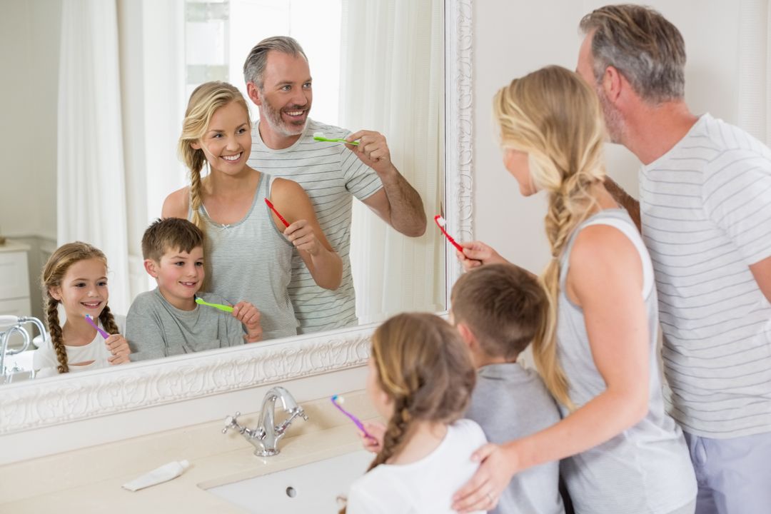 Parents and kids brushing teeth in bathroom - Free Images, Stock Photos and Pictures on Pikwizard.com