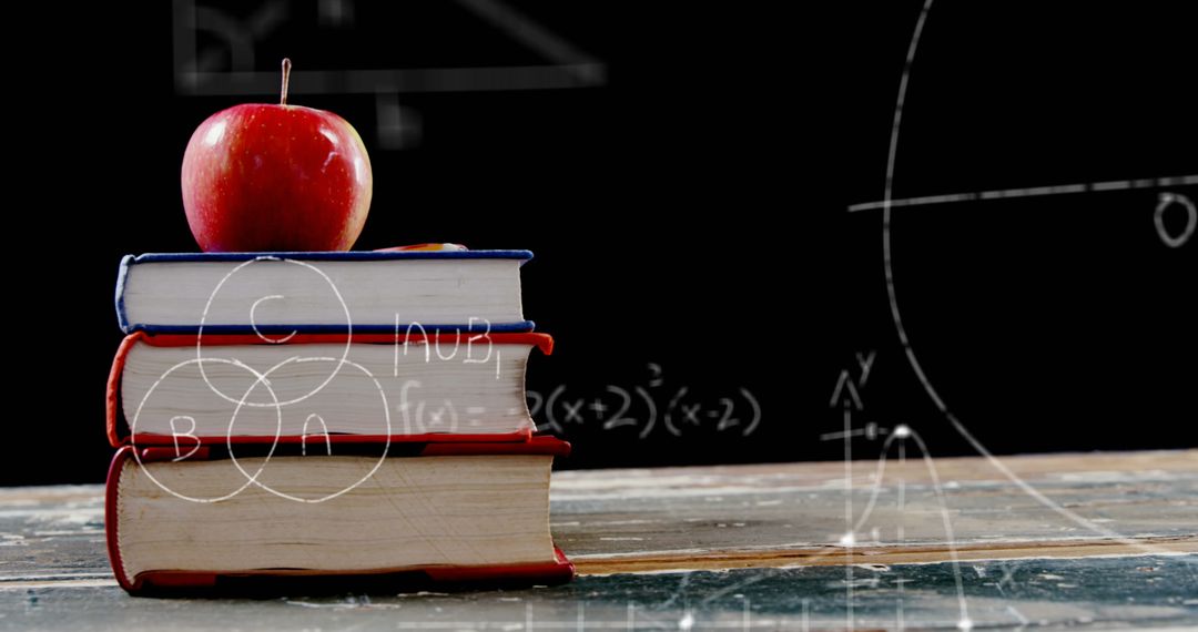 Books with Apple and Mathematical Equations on Blackboard