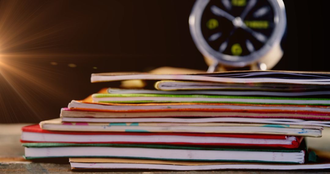 Glowing Alarm Clock Resting on Colorful Stack of Books