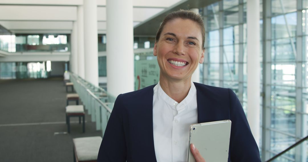 Professional Businesswoman Smiling with Tablet in Modern Office - Free Images, Stock Photos and Pictures on Pikwizard.com