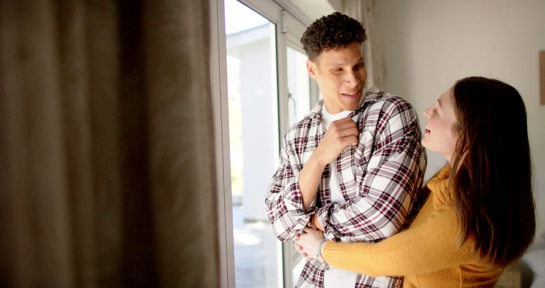 Joyful Multiethnic Couple Exploring Bright Future at Home